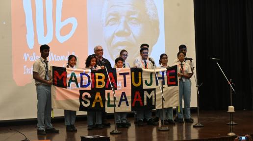 A school student choir holds up a cloth banner that reads 'Madiba Tujhe Salaam' (Madiba we salute you), created by a tribal community in Jharkhand, at the Nelson Mandela International Day 2024 event at India International Centre, New Delhi. 